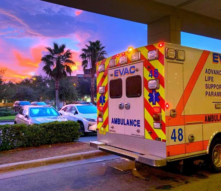 Emergency responders unloaded a senior into an ambulance at night, illustrating the need for urgent home watch care during senior medical emergencies.
