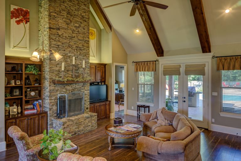 Whether aging in place or away temporarily, our visits ensure the home is cared for with detailed checks, clear reports, and trusted support families and seniors can count on. Comfortable senior home interior with vaulted ceiling and fireplace, symbolizing safety and consistent home care.